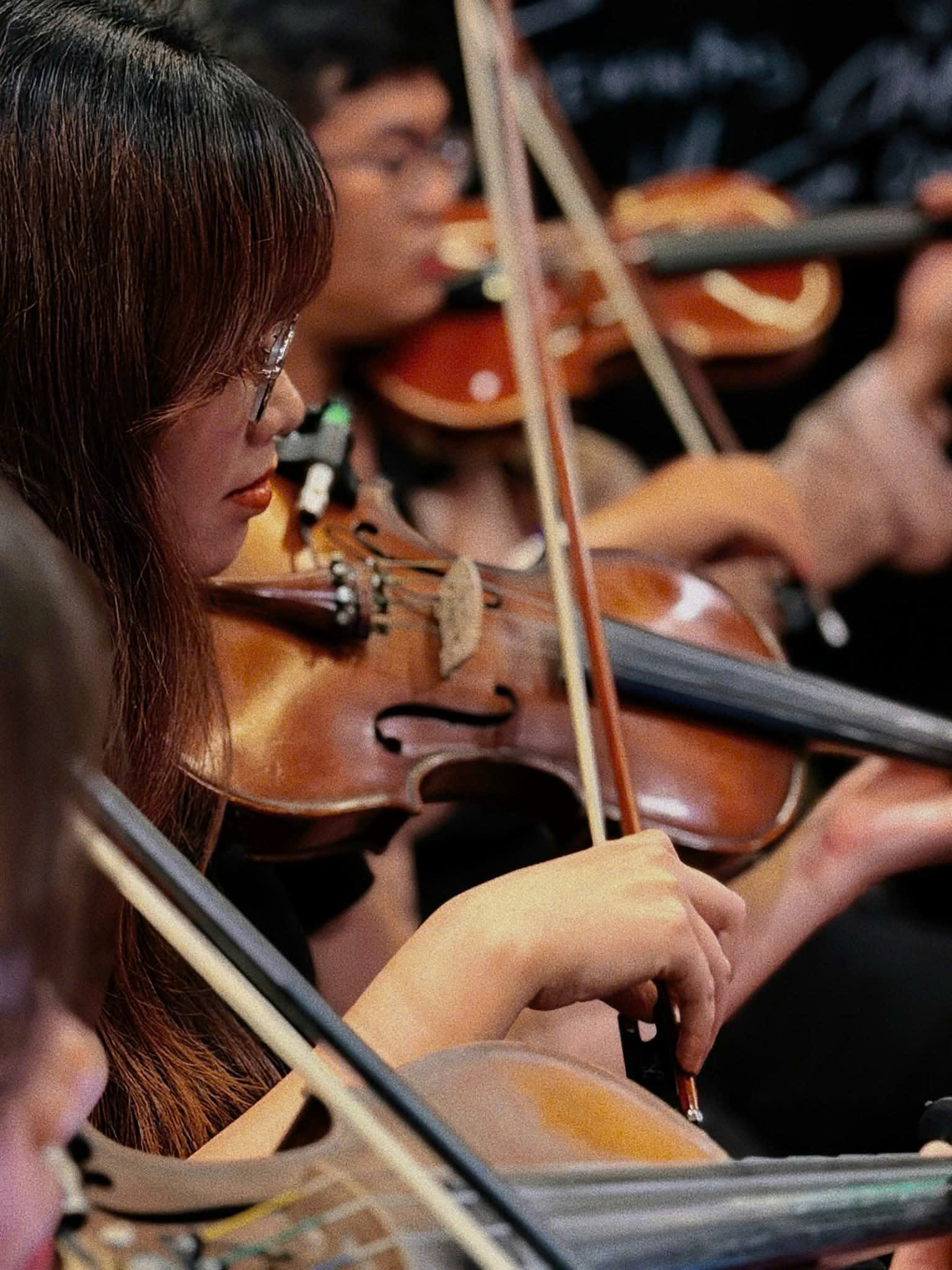 Hạ Vy playing violin alongside other string musicians